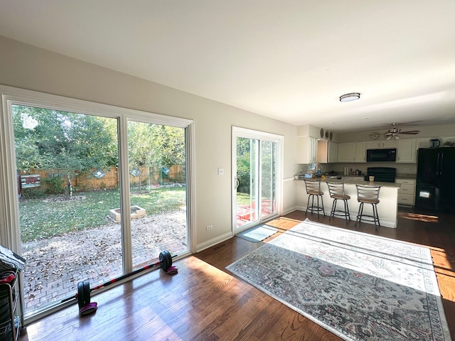 living room with ceiling fan, dark hardwood / wood-style floors, and a healthy amount of sunlight