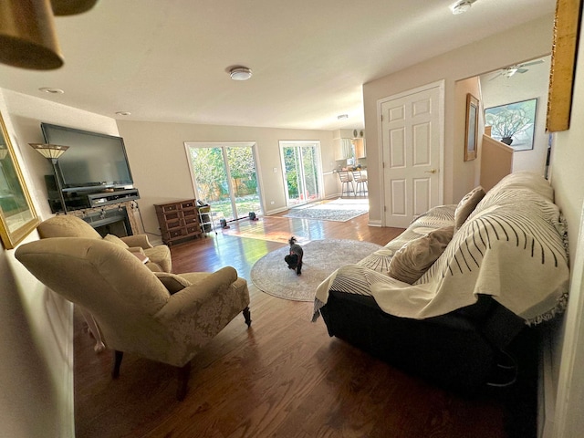 living room featuring wood-type flooring, vaulted ceiling, and ceiling fan