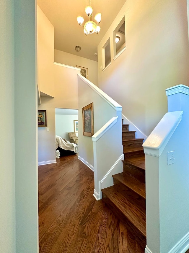 stairway with a notable chandelier and wood-type flooring