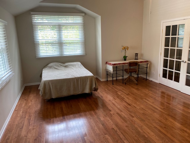 bedroom with wood-type flooring and vaulted ceiling