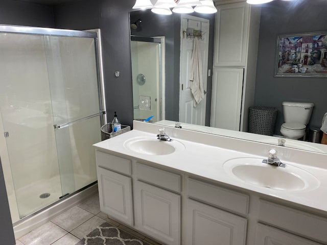 bathroom with vanity, toilet, tile patterned floors, and a shower with shower door