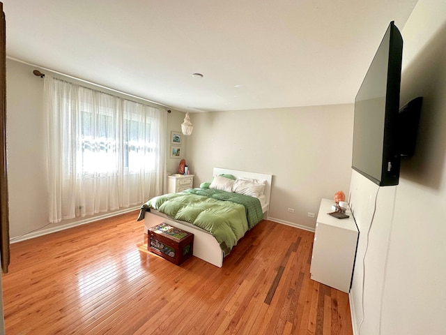 bedroom featuring lofted ceiling and light hardwood / wood-style flooring