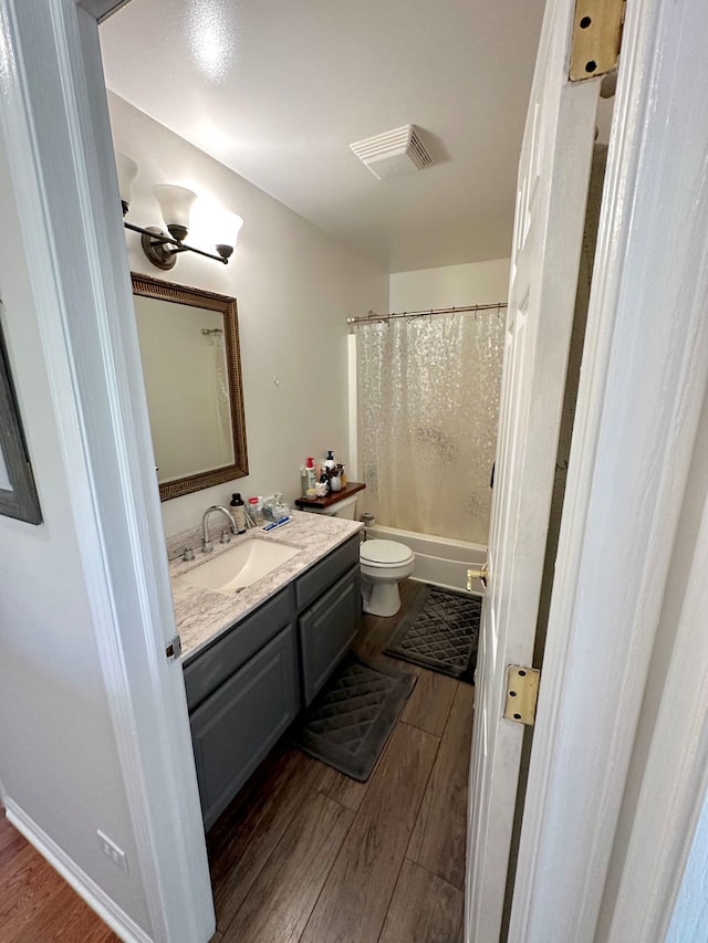 full bathroom featuring shower / tub combo, vanity, toilet, and hardwood / wood-style flooring