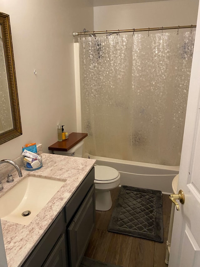 full bathroom with shower / bath combination with curtain, hardwood / wood-style flooring, vanity, and toilet