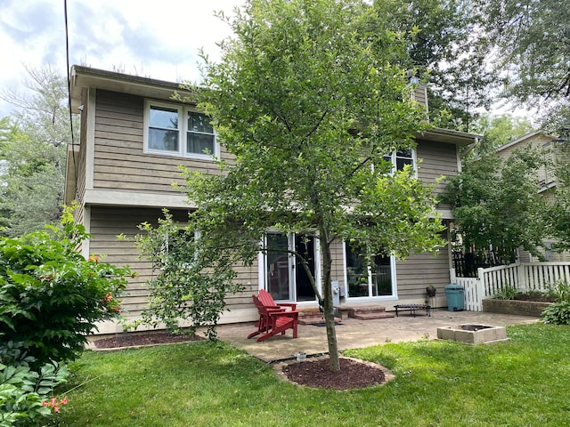 back of house with a lawn and a patio area