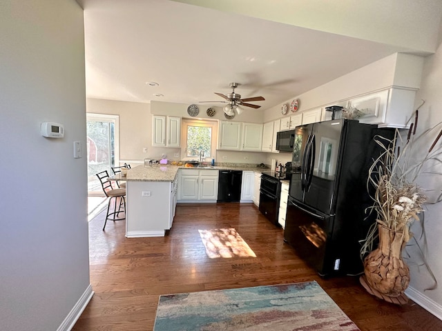 kitchen featuring dark hardwood / wood-style floors, sink, white cabinetry, black appliances, and ceiling fan