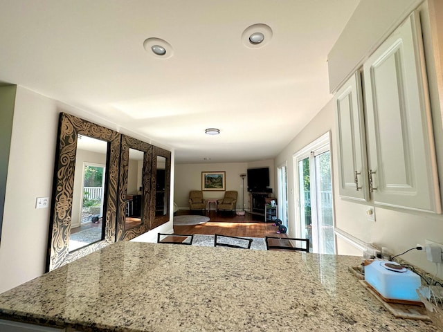 kitchen featuring light stone countertops, hardwood / wood-style flooring, plenty of natural light, and french doors