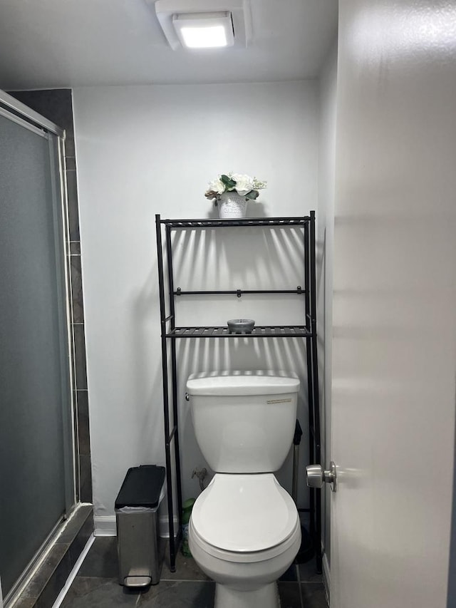 bathroom featuring an enclosed shower, tile patterned floors, and toilet