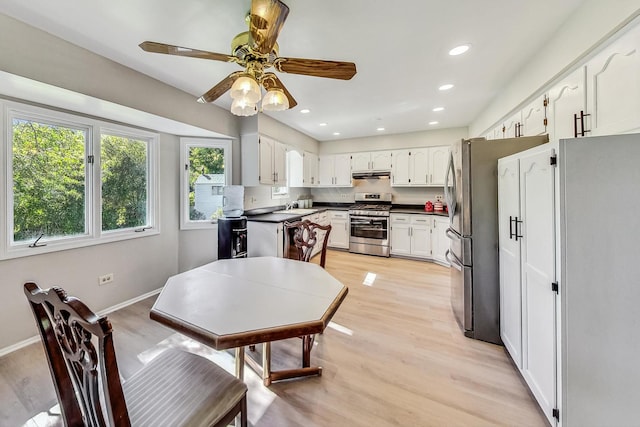 kitchen with ceiling fan, white cabinets, sink, stainless steel appliances, and light wood-type flooring