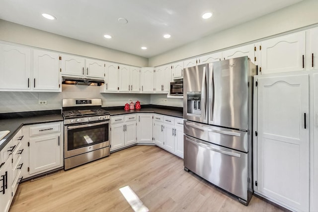 kitchen with appliances with stainless steel finishes, white cabinetry, and light hardwood / wood-style flooring