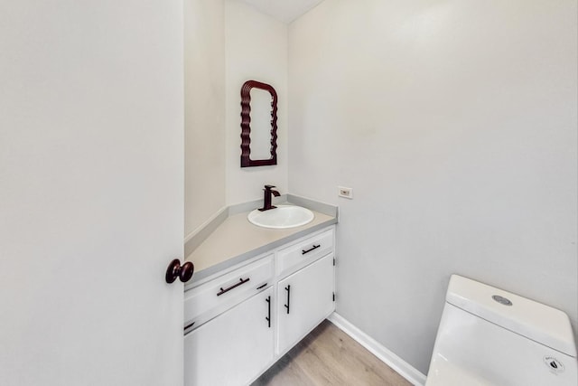 bathroom featuring hardwood / wood-style flooring, vanity, and toilet