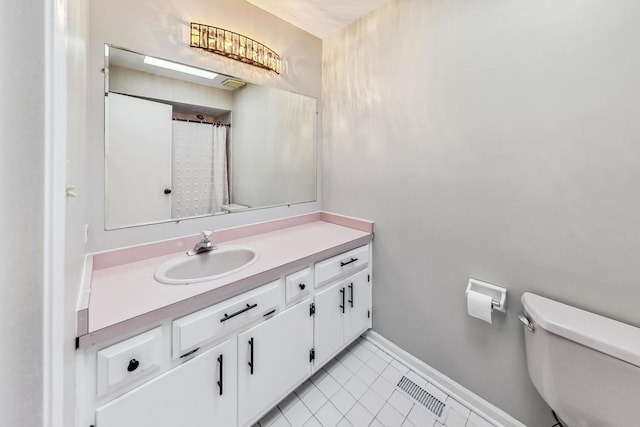 bathroom with vanity, toilet, and tile patterned floors