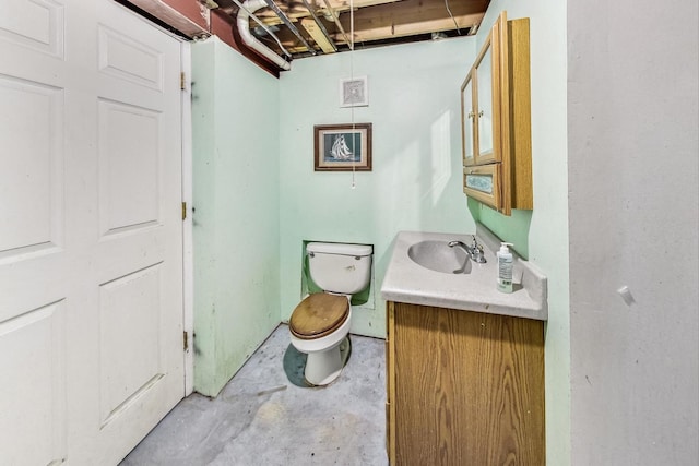 bathroom with vanity, toilet, and concrete floors