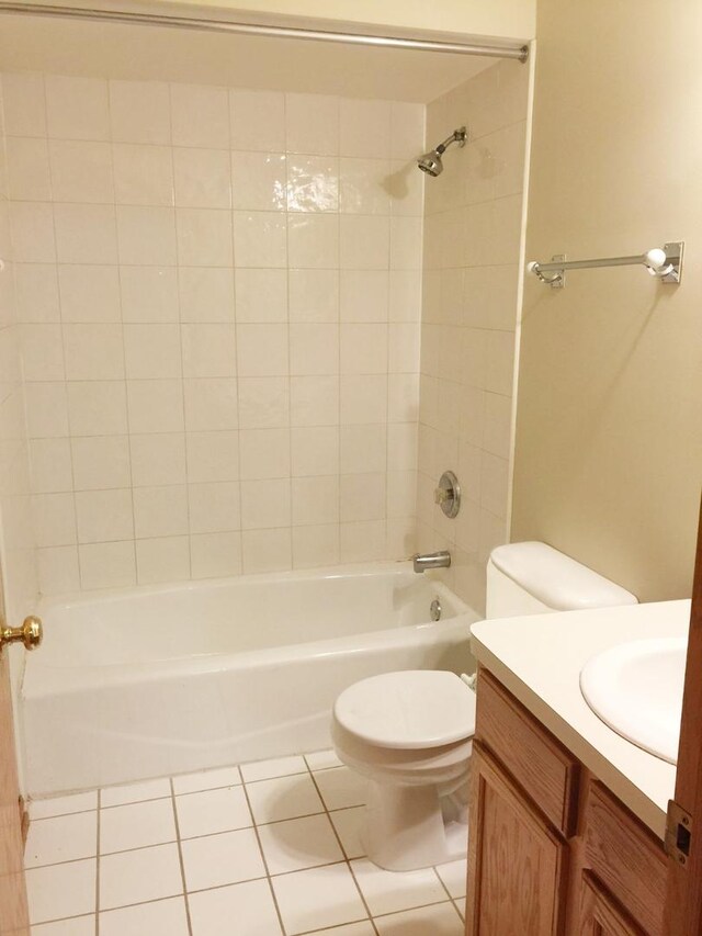 full bathroom with vanity, tile patterned flooring, tiled shower / bath, and toilet