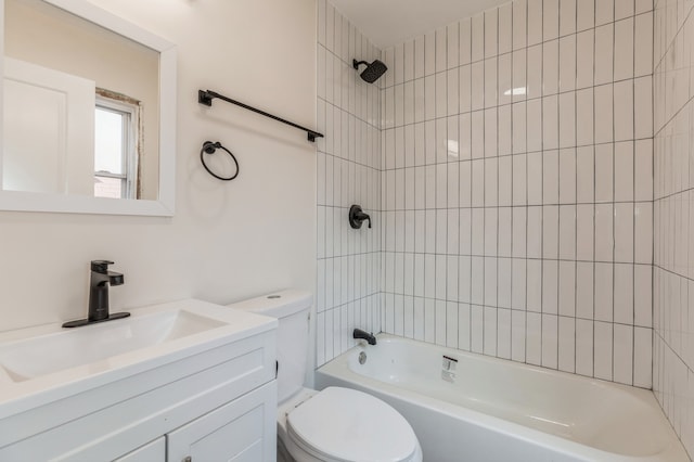 full bathroom featuring tiled shower / bath, vanity, and toilet