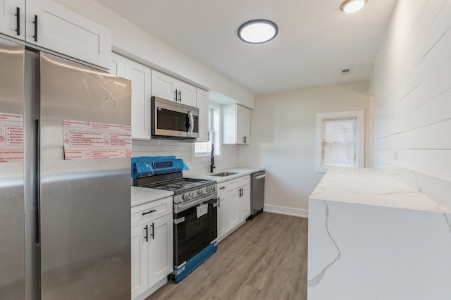 kitchen with white cabinetry, stainless steel appliances, and sink