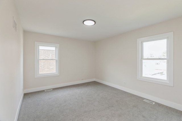 unfurnished room featuring light carpet