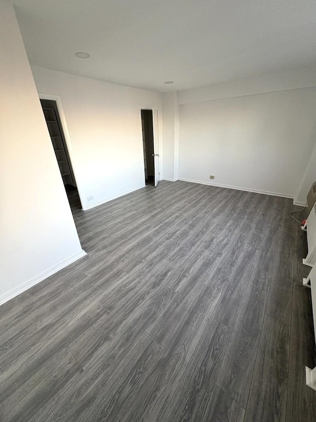 empty room with dark hardwood / wood-style flooring