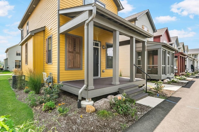 view of property exterior with a porch and a sunroom