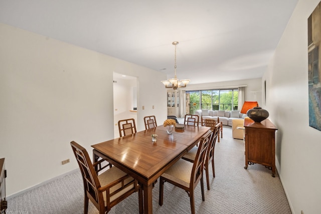 dining room featuring an inviting chandelier and light colored carpet