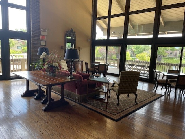 living room with beam ceiling, wood-type flooring, and high vaulted ceiling