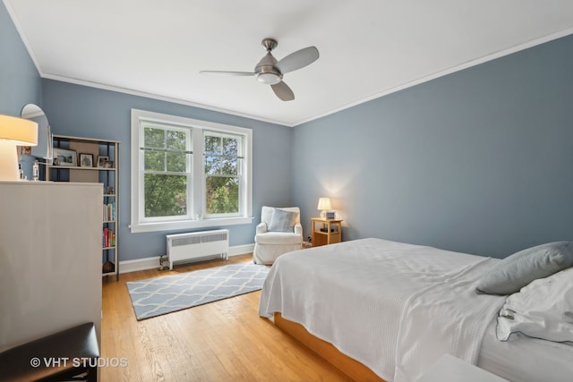 bedroom featuring ceiling fan, crown molding, light hardwood / wood-style flooring, and radiator