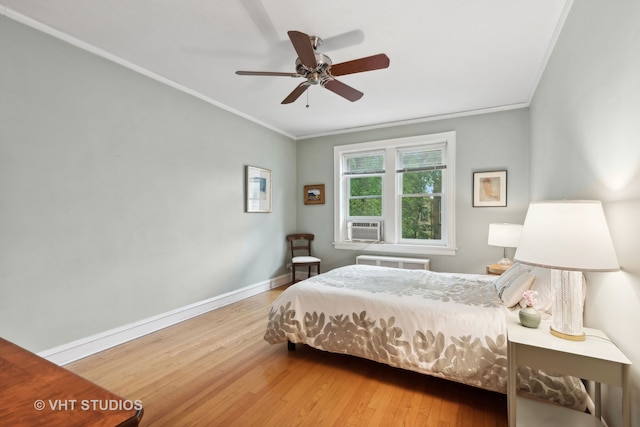 bedroom with light hardwood / wood-style floors, ornamental molding, and ceiling fan