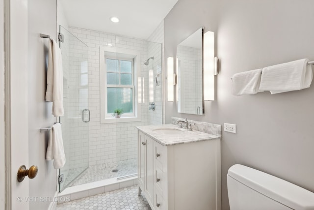 bathroom featuring vanity, walk in shower, tile patterned flooring, and toilet