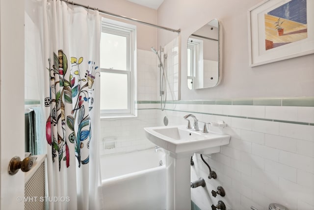 bathroom featuring tasteful backsplash, tile walls, and shower / bath combination with curtain