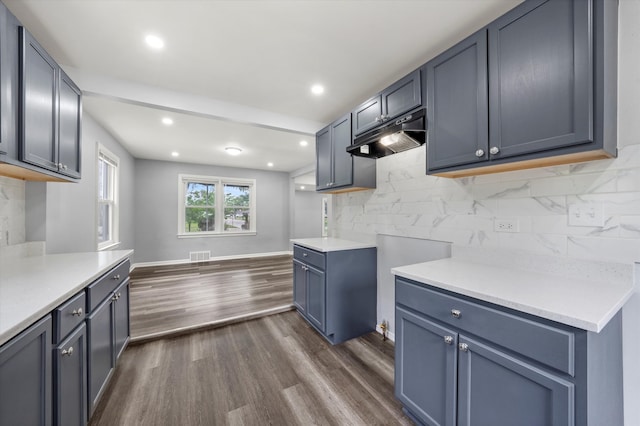 kitchen with decorative backsplash and dark wood-type flooring