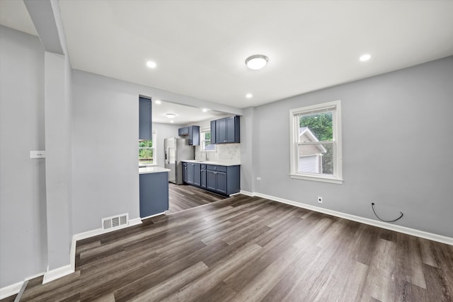 unfurnished living room featuring sink and dark hardwood / wood-style floors