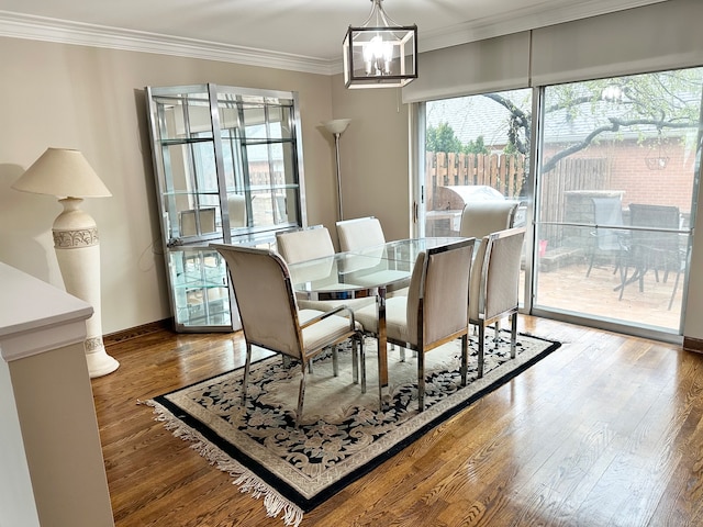 dining area with ornamental molding, dark hardwood / wood-style flooring, and a chandelier