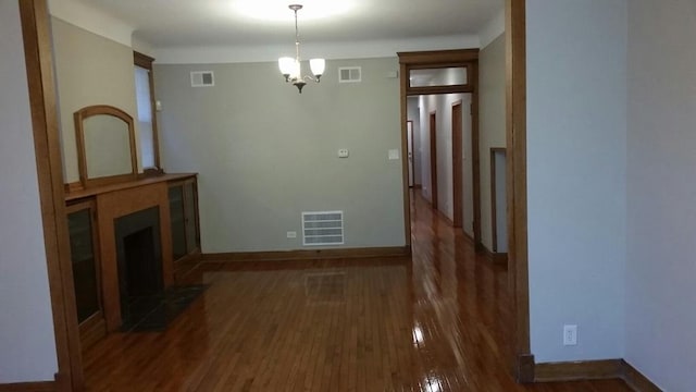 interior space with a large fireplace, visible vents, and wood finished floors