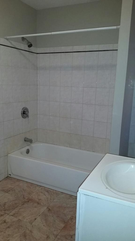 full bath featuring vanity and washtub / shower combination