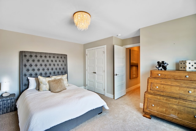 carpeted bedroom with a closet and an inviting chandelier