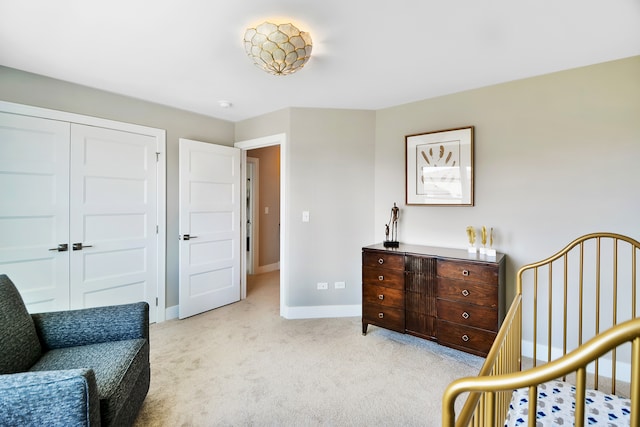 carpeted bedroom with a crib and a closet