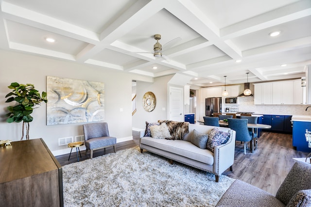 living room with beamed ceiling, ceiling fan, hardwood / wood-style floors, and coffered ceiling