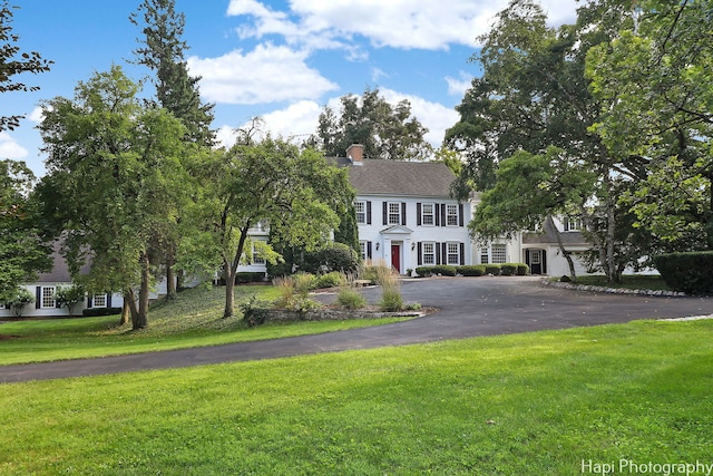 colonial home with a garage and a front yard