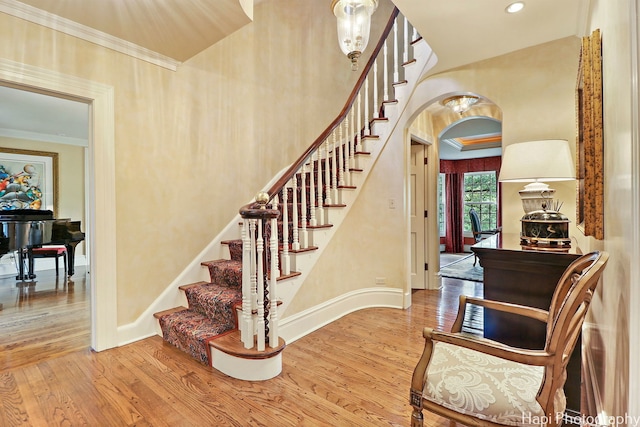 staircase featuring crown molding and light hardwood / wood-style floors