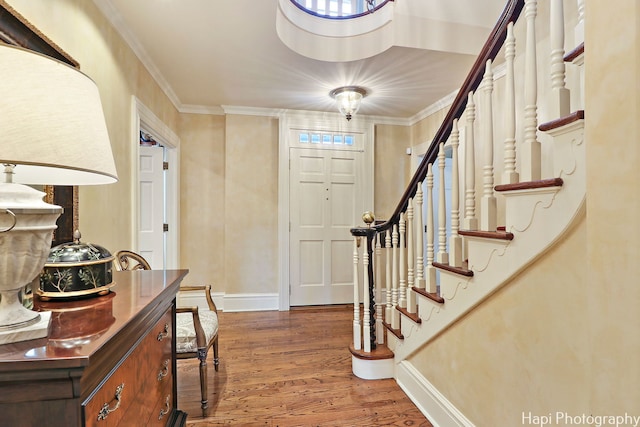 foyer entrance featuring crown molding and hardwood / wood-style flooring