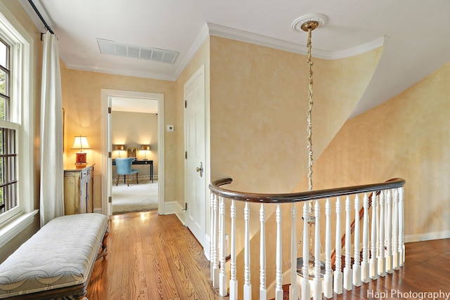 hallway with hardwood / wood-style floors and ornamental molding