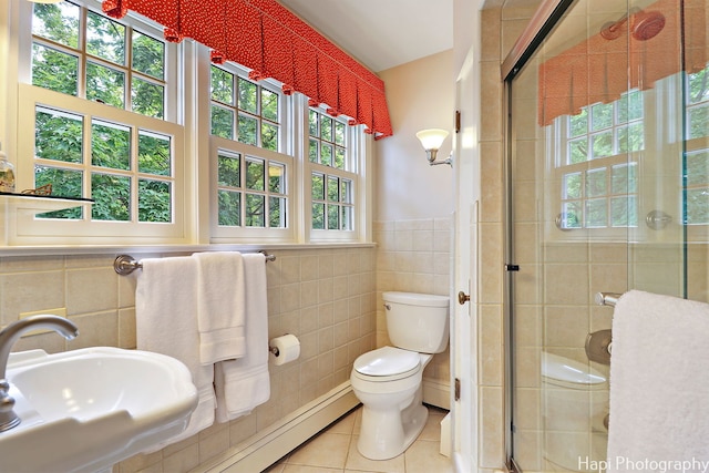 bathroom featuring tile patterned floors, tile walls, toilet, and sink