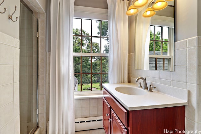 bathroom with tile walls, baseboard heating, vanity, and plenty of natural light