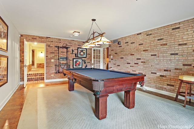 rec room with billiards and brick wall