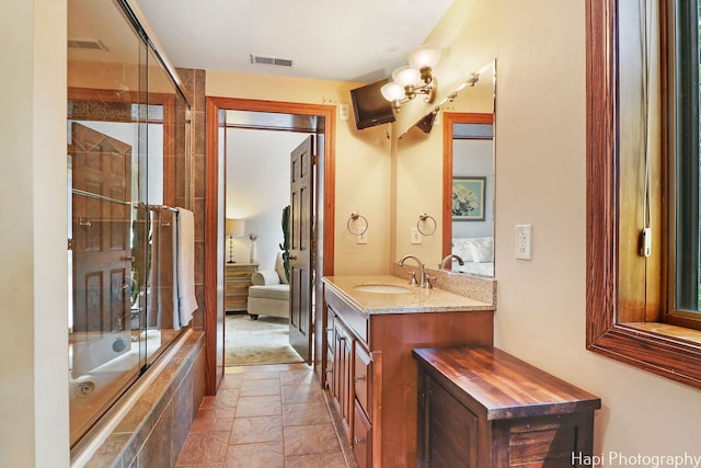 bathroom featuring combined bath / shower with glass door, vanity, and tile patterned flooring