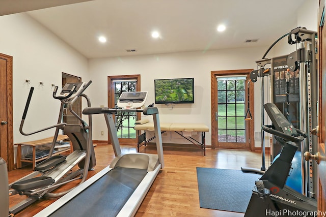 workout area with light hardwood / wood-style flooring