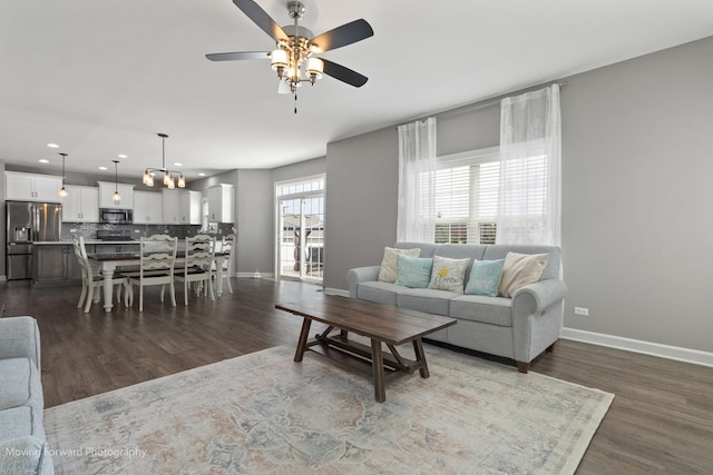 living room featuring ceiling fan and dark hardwood / wood-style floors