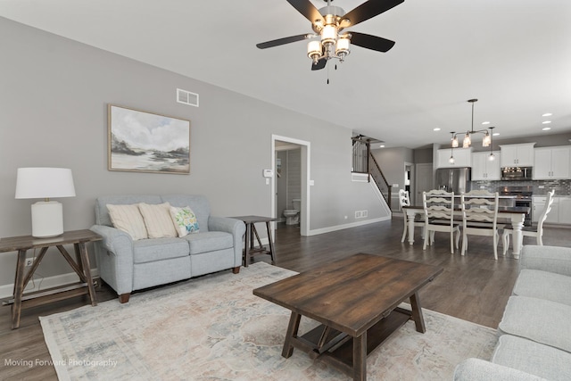 living room featuring wood-type flooring and ceiling fan