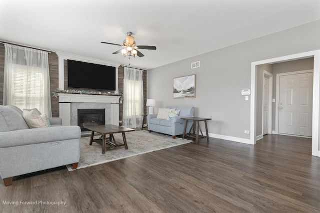 living room featuring dark hardwood / wood-style flooring, a fireplace, and ceiling fan