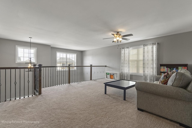 living room with carpet flooring and ceiling fan with notable chandelier